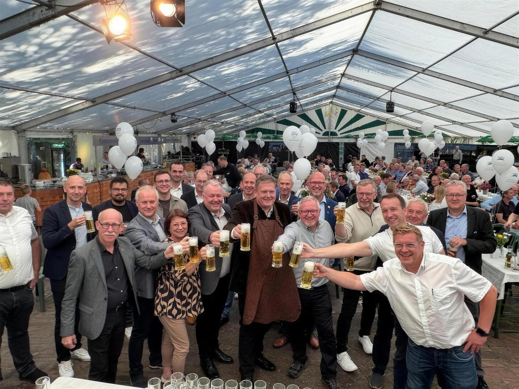 Mitglieder des Gewerbevereins stoßen beim Stemweder Markt 2025 im Festzelt an